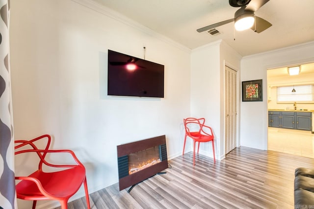 125 Carl Dr, Hot Springs, AR 71913 - living area with a warm lit fireplace, visible vents, crown molding, ceiling fan, and wood finished floors