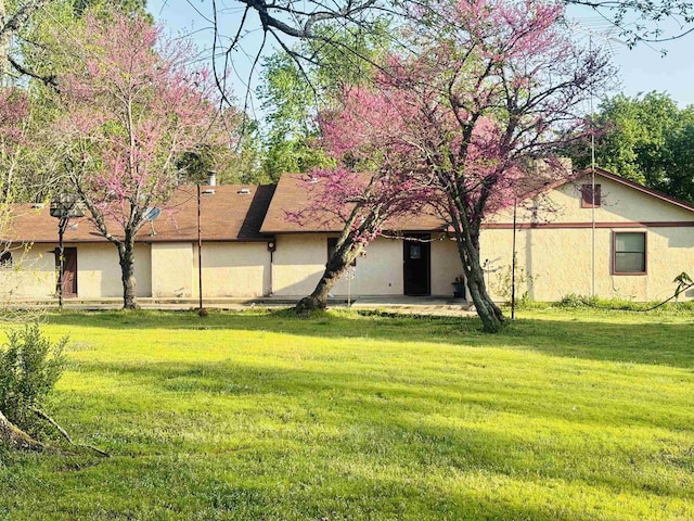 126 Dallas Ln, Mena, AR 71953 - rear view of property featuring a yard, stucco siding, and a patio area