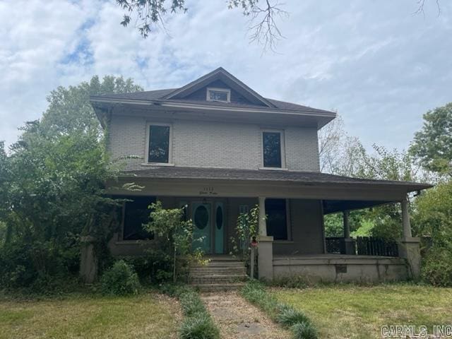 view of front of house featuring a porch and brick siding