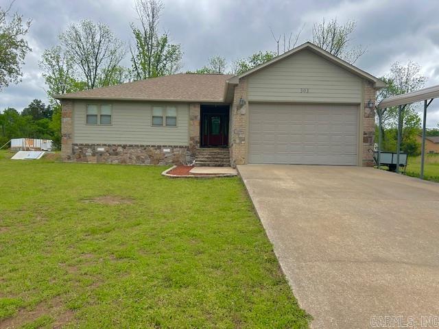 ranch-style house with an attached garage, a front lawn, driveway, and brick siding
