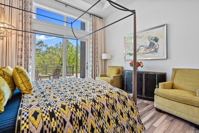 bedroom with access to outside and wood finished floors