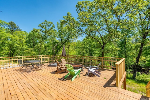 wooden terrace with a fire pit and outdoor dining area