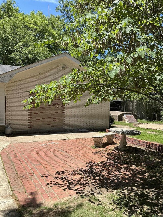 206 W High St, Sheridan, AR 72150 - view of side of home featuring brick siding and a patio area