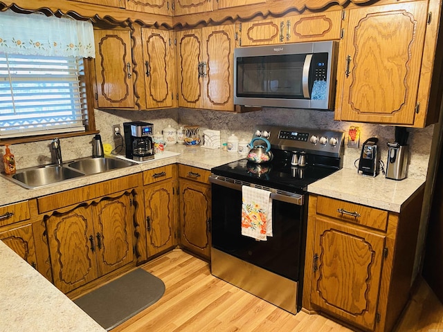 164 Polk Road 714, Mena, AR 71953 - kitchen featuring light countertops, a sink, appliances with stainless steel finishes, light wood-style floors, and decorative backsplash