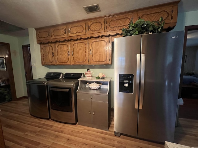 164 Polk Road 714, Mena, AR 71953 - washroom featuring light wood finished floors, visible vents, washing machine and clothes dryer, and laundry area