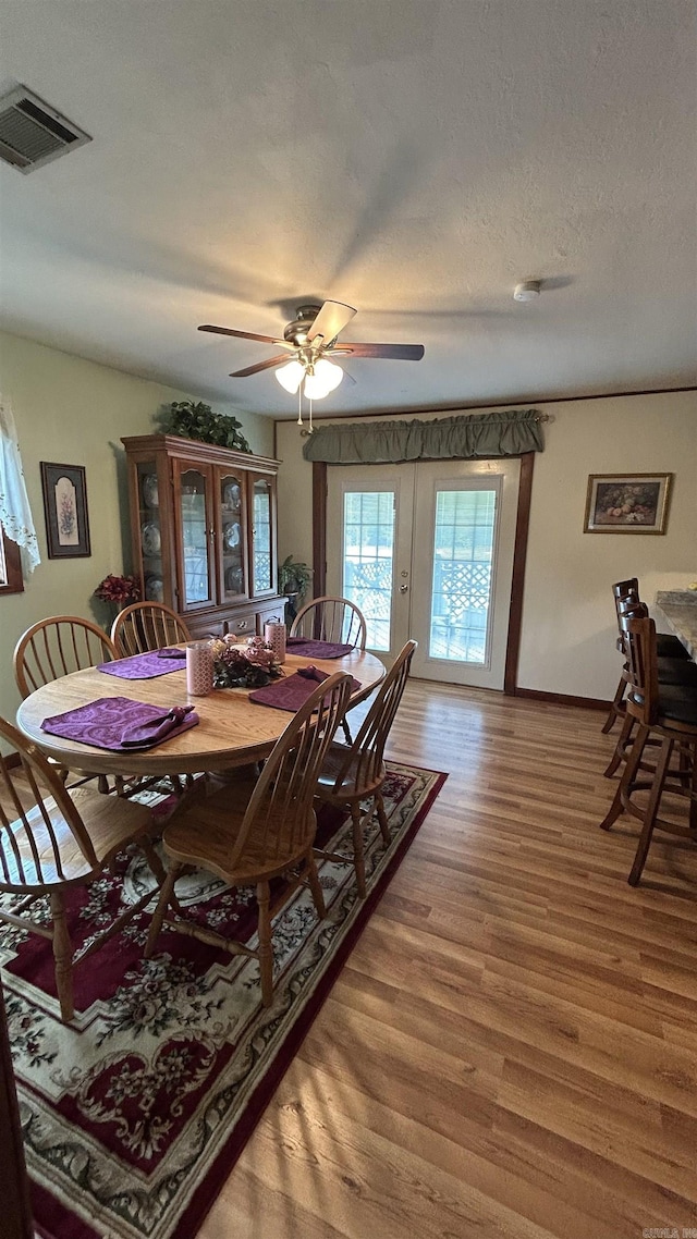 164 Polk Road 714, Mena, AR 71953 - dining space featuring a textured ceiling, visible vents, baseboards, wood finished floors, and a ceiling fan