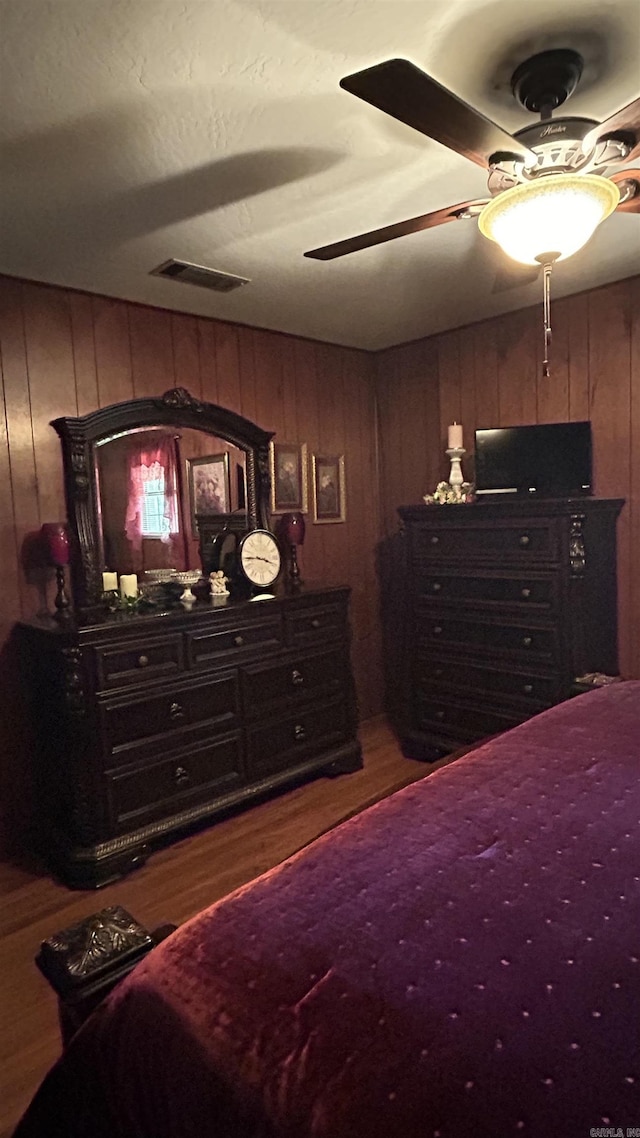 164 Polk Road 714, Mena, AR 71953 - bedroom with a ceiling fan, visible vents, wooden walls, and wood finished floors