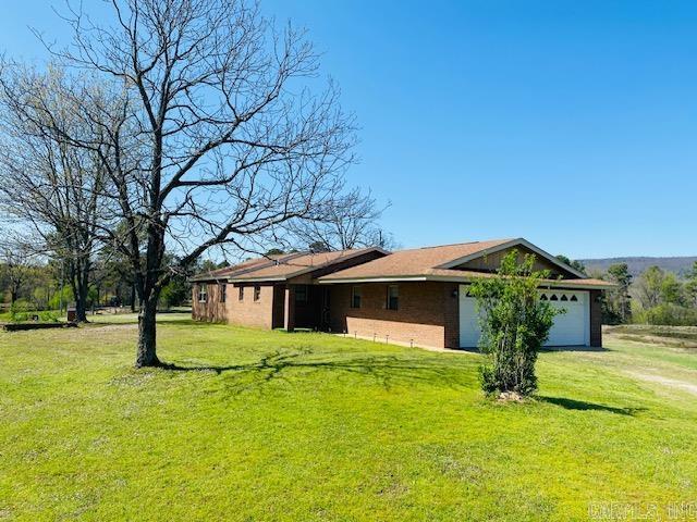 164 Polk Rd Unit 714, Mena, AR 71953 - view of side of home with a lawn, dirt driveway, and a garage