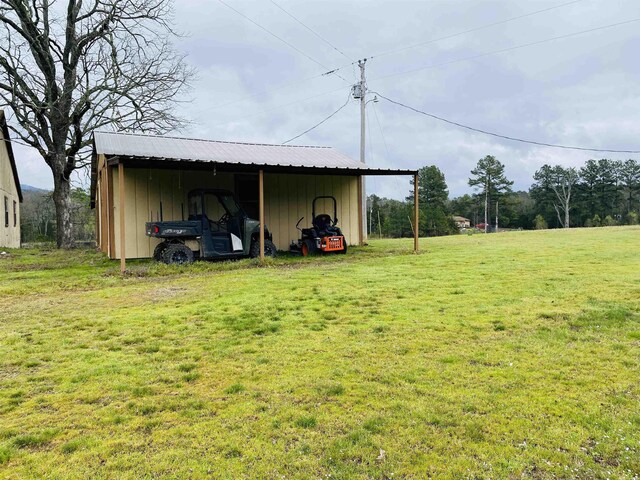 164 Polk Rd Unit 714, Mena, AR 71953 - view of pole building with a lawn and an attached carport