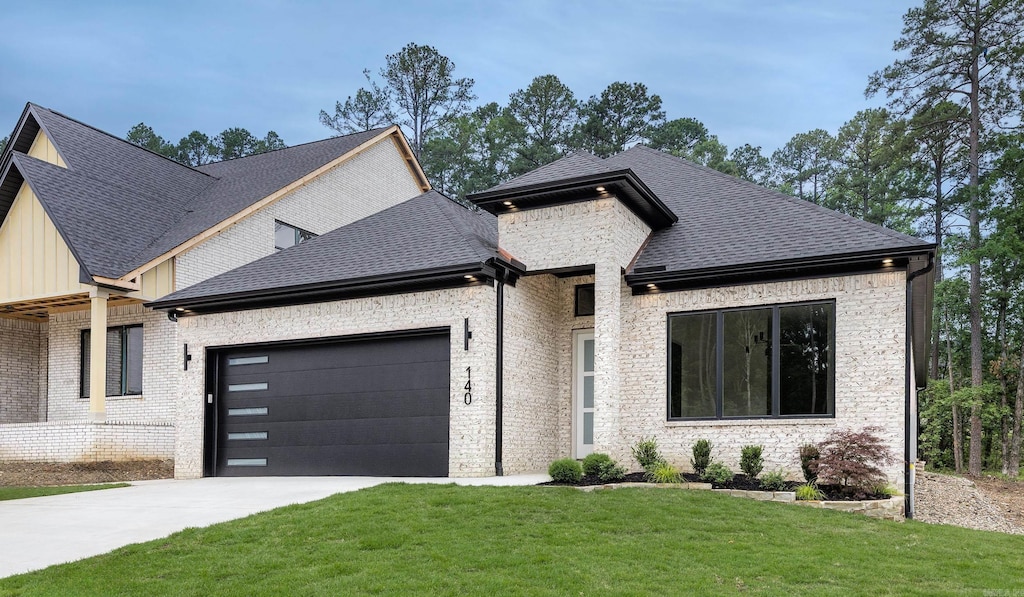 140 Calion Ct, Little Rock, AR 72223 - view of front of house with a garage, a front yard, driveway, a shingled roof, and brick siding