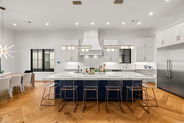 5204 Stonewall Rd, Little Rock, AR 72207 - kitchen with a spacious island, backsplash, built in refrigerator, custom exhaust hood, and ornamental molding