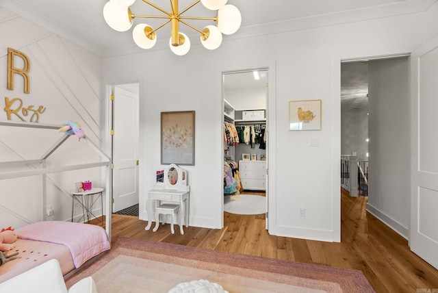 5204 Stonewall Rd, Little Rock, AR 72207 - bedroom featuring a closet, ornamental molding, wood finished floors, a walk in closet, and a notable chandelier