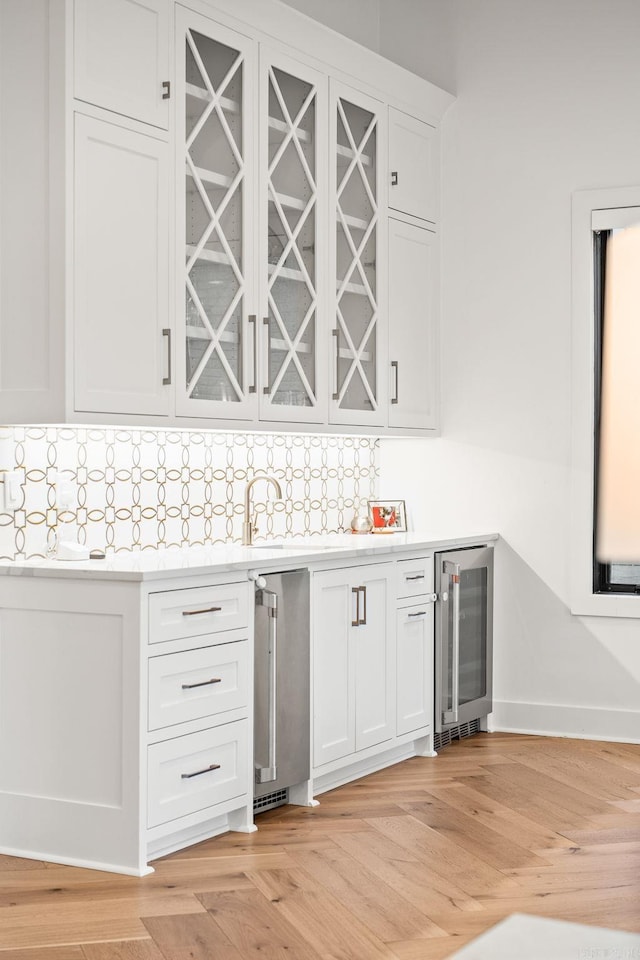 5204 Stonewall Rd, Little Rock, AR 72207 - bar with baseboards, tasteful backsplash, a dry bar, light wood-type flooring, and beverage cooler
