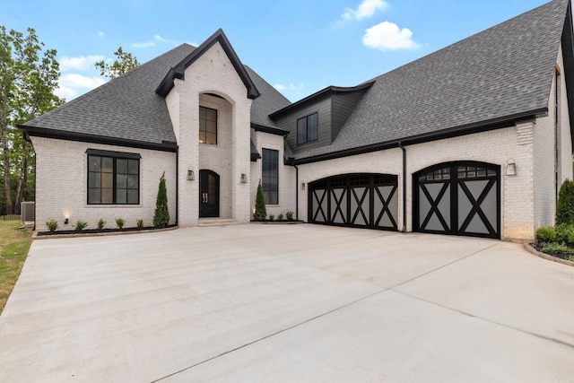 125 Hallen Ln, Little Rock, AR 72223 - french country home featuring brick siding, concrete driveway, a shingled roof, and a garage