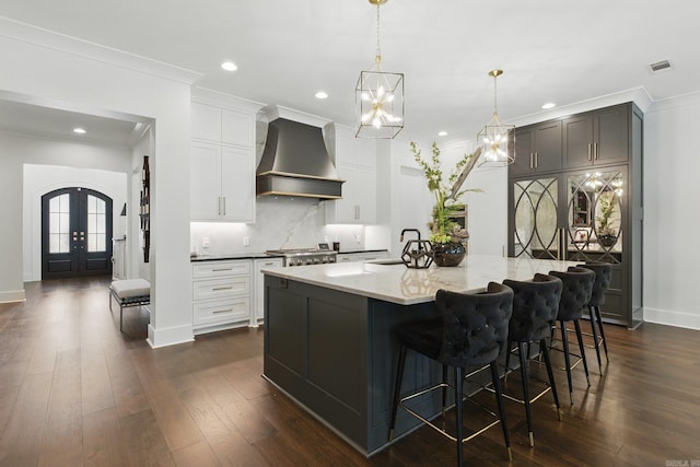 125 Hallen Ln, Little Rock, AR 72223 - kitchen featuring ornamental molding, dark wood finished floors, tasteful backsplash, custom range hood, and french doors