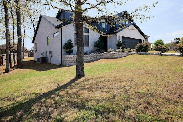 9 Marchwood Cv, Little Rock, AR 72210 - view of property exterior featuring a lawn, a garage, and brick siding
