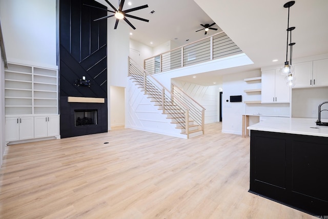 9 Marchwood Cv, Little Rock, AR 72210 - living room with a fireplace, ceiling fan, stairway, and light wood-type flooring