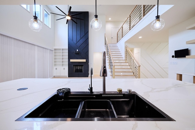 9 Marchwood Cv, Little Rock, AR 72210 - kitchen with a high ceiling, light stone countertops, a large fireplace, and pendant lighting