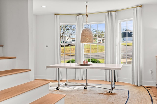 dining area featuring baseboards, wood finished floors, and recessed lighting