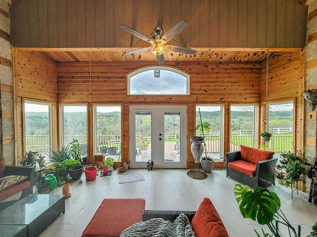 sunroom / solarium featuring french doors and a towering ceiling