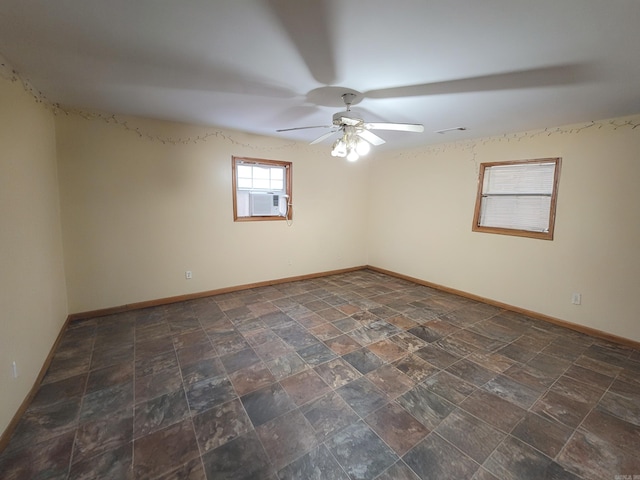 unfurnished room with stone finish flooring, a ceiling fan, cooling unit, baseboards, and visible vents