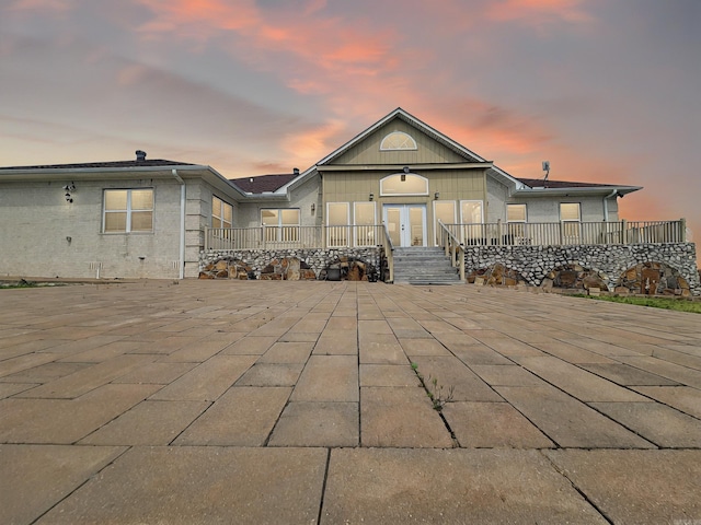 back of property with french doors, a deck, and a patio area