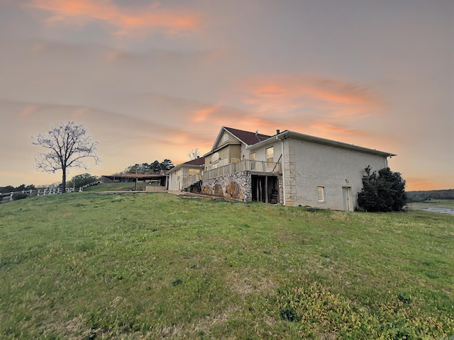 exterior space featuring stucco siding, stone siding, and a yard