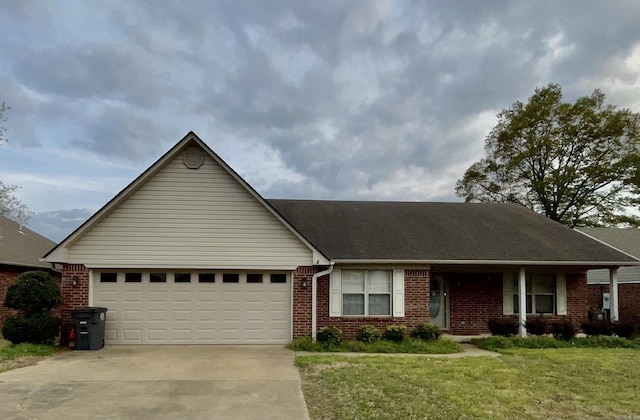 ranch-style home with brick siding, a front yard, driveway, and a garage
