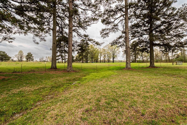 view of yard featuring fence and a rural view