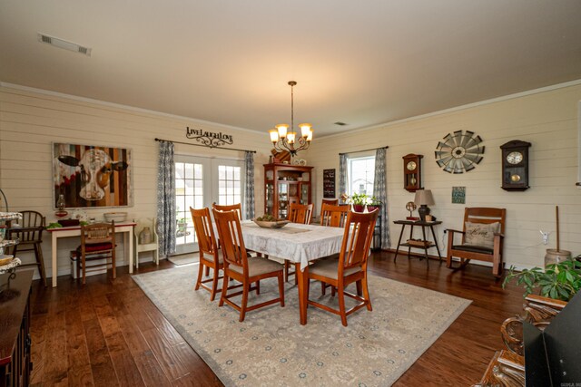 dining room featuring dark wood-style floors, visible vents, a notable chandelier, and ornamental molding