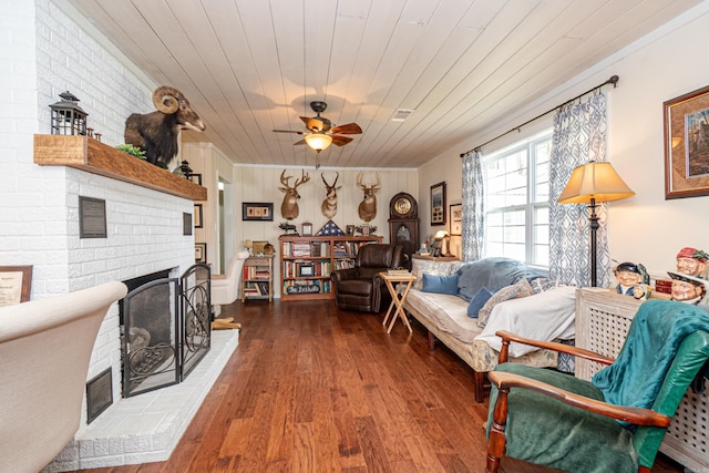 living room featuring a brick fireplace, wooden ceiling, ceiling fan, and wood finished floors