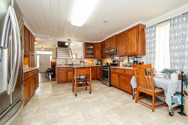 kitchen with wood ceiling, appliances with stainless steel finishes, under cabinet range hood, and brown cabinets