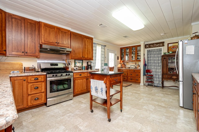 kitchen featuring crown molding, appliances with stainless steel finishes, under cabinet range hood, and brown cabinets