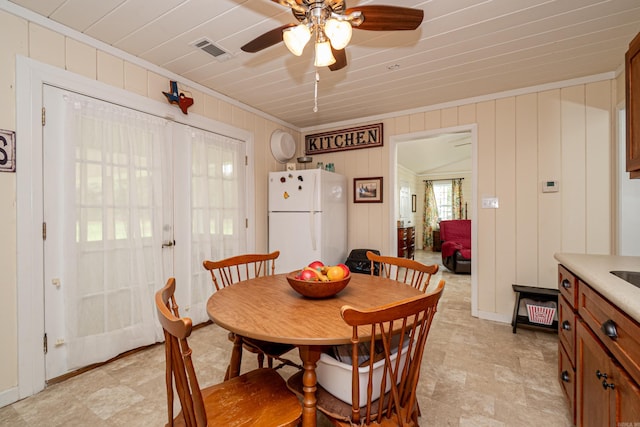 dining space with crown molding, baseboards, visible vents, and a ceiling fan