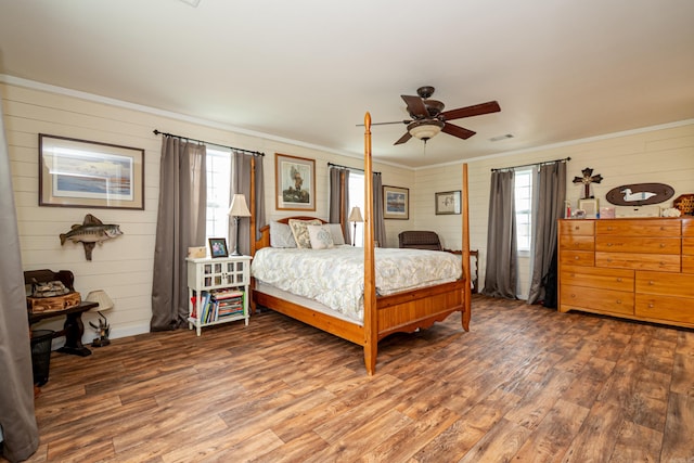 bedroom featuring visible vents, ornamental molding, wood finished floors, and a ceiling fan