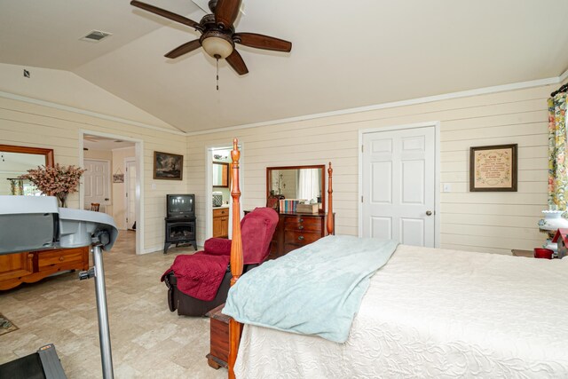 bedroom featuring ceiling fan, wooden walls, vaulted ceiling, and visible vents