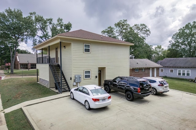 view of front of home with stairs, covered porch, and a front yard