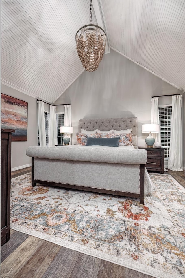 bedroom with an inviting chandelier, baseboards, vaulted ceiling, and wood finished floors