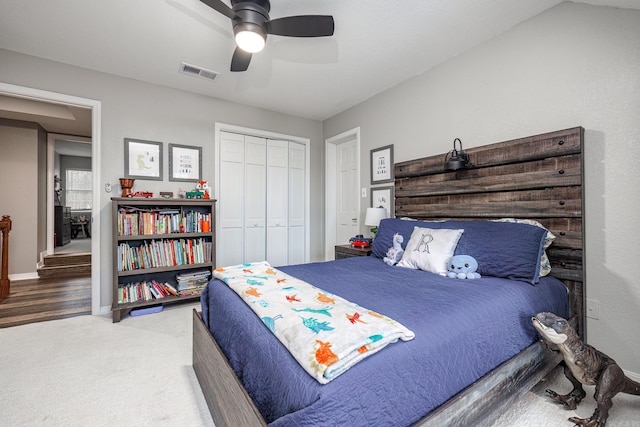bedroom featuring a closet, carpet flooring, visible vents, baseboards, and a ceiling fan