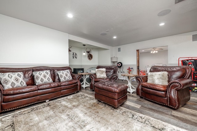 living room featuring a wainscoted wall, a textured ceiling, ceiling fan, wood finished floors, and recessed lighting