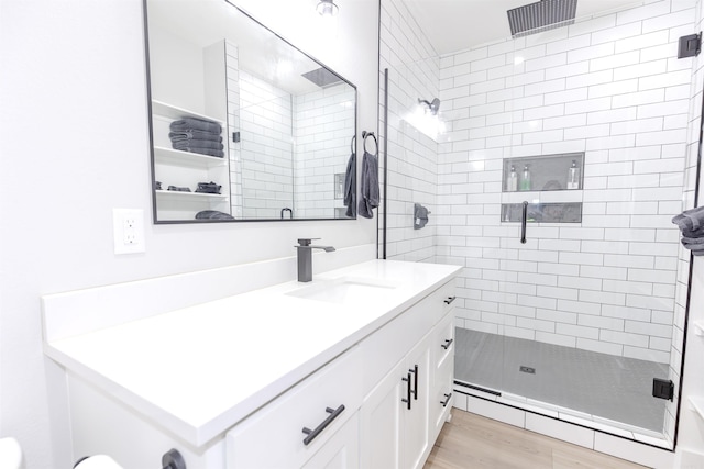 full bathroom with wood finished floors, vanity, and a shower stall