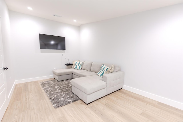 living room featuring baseboards, visible vents, light wood-style flooring, and recessed lighting