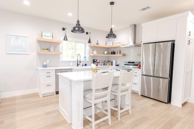 kitchen featuring light countertops, open shelves, stainless steel appliances, visible vents, and wall chimney range hood
