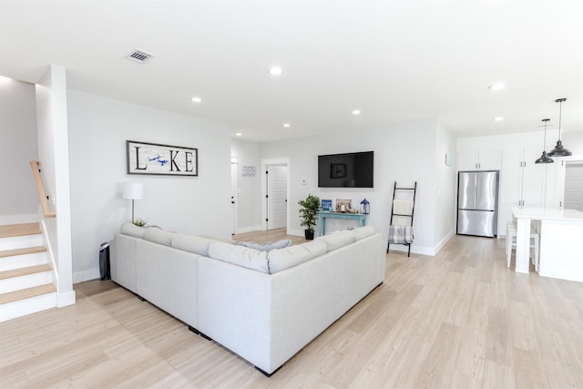 living area featuring light wood finished floors, stairs, visible vents, and recessed lighting