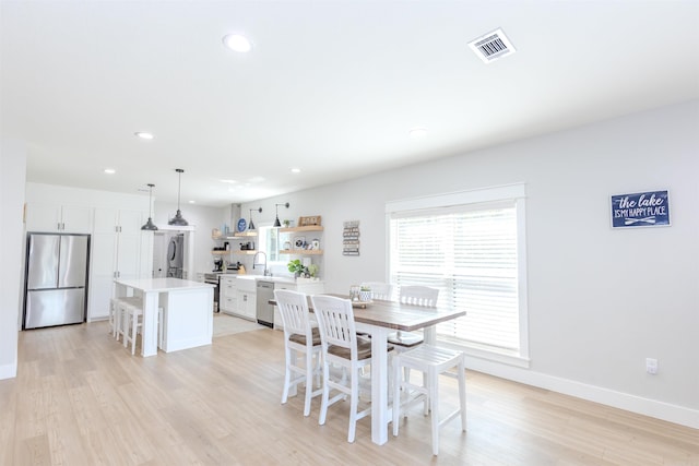 dining space with recessed lighting, baseboards, light wood finished floors, and visible vents