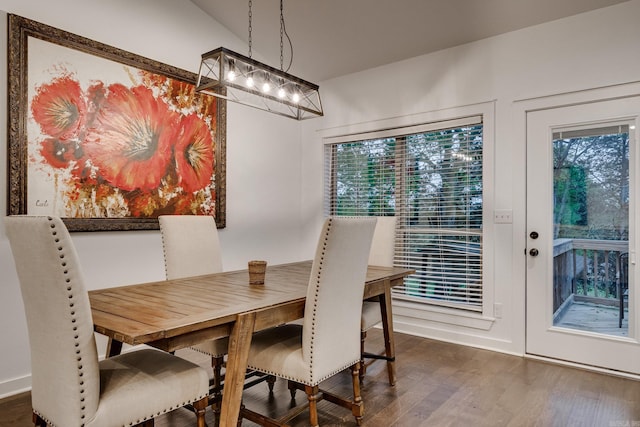 dining space with a healthy amount of sunlight, a chandelier, and dark wood finished floors