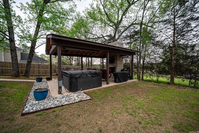 view of yard featuring a hot tub, a fenced backyard, a gazebo, and a patio area