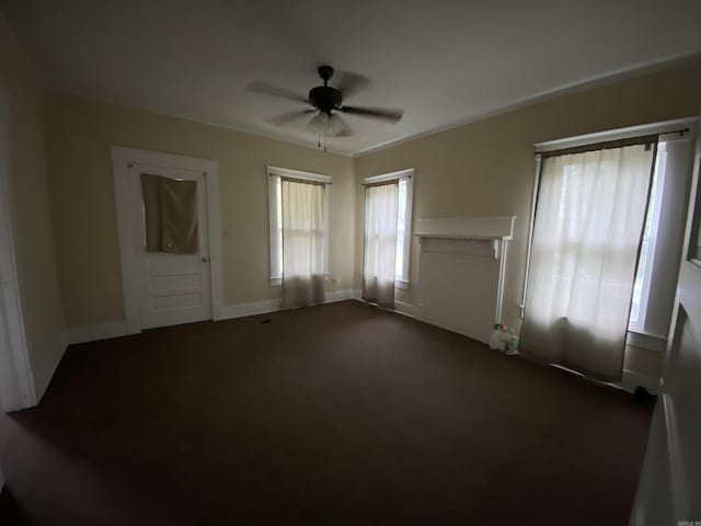 141 N Church St, Mineral Sprs, AR 71851 - unfurnished living room with baseboards, ceiling fan, and dark colored carpet