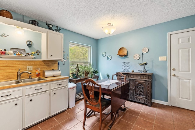 3613 Northlake Rd, Alexander, AR 72002 - dining room with a textured ceiling, dark tile patterned flooring, and baseboards