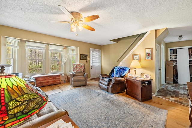 3613 Northlake Rd, Alexander, AR 72002 - living room featuring a ceiling fan, a textured ceiling, stairway, and light wood-type flooring